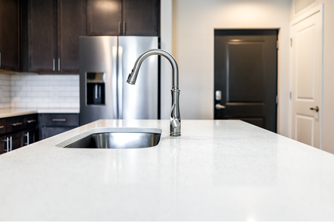 Quartz countertops are consistent and quick to fabricate, require few components, and manufacturers are keeping large amounts ready to cut and install.